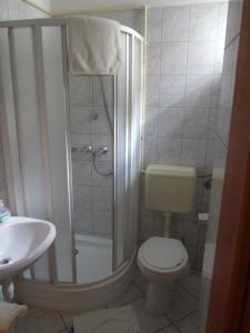 een badkamer met een douche, een toilet en een wastafel bij Hotel Diána in Pécs