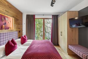 a bedroom with a bed with pink pillows at Nationalpark Chalet Blessachkopf in Neukirchen am Großvenediger
