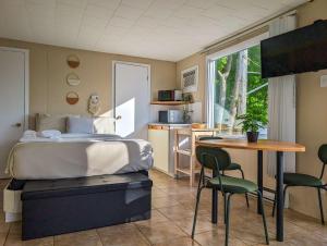 a bedroom with a bed and a table and a kitchen at Chalet Studio #12 - Relaxing getaway with Wifi & AC in Cap-Saint-Ignace
