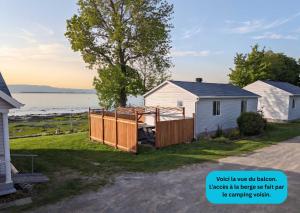 a house with a wooden fence in front of a yard at Chalet Studio #12 - Relaxing getaway with Wifi & AC in Cap-Saint-Ignace