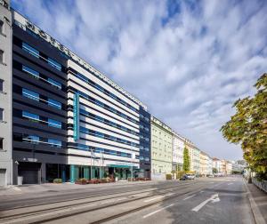 a large building with blue windows on a city street at Occidental Praha Five in Prague