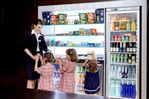 a woman and two children in front of a refrigerator at Occidental Praha Five in Prague +26 photos