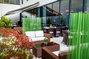 a patio with chairs and tables and green columns at Occidental Praha Five in Prague