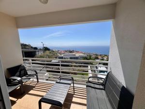 a balcony with benches and a view of the ocean at Caniço Lodge in Caniço
