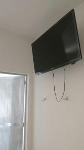 a flat screen tv hanging on a wall at Pousada JM in Parque Dom Bosco