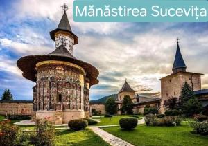 a building with a tower in front of a castle at Life-forever in Suceviţa