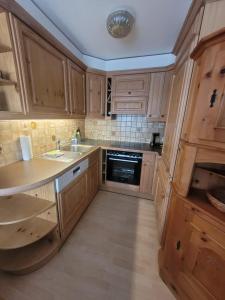 a kitchen with wooden cabinets and a sink and a stove at Wohnung in Andermatt in Andermatt +2 photos