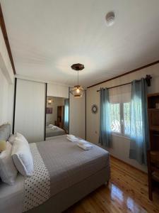 a bedroom with a bed and a window with blue curtains at Blue Horizon Balcony in Volos