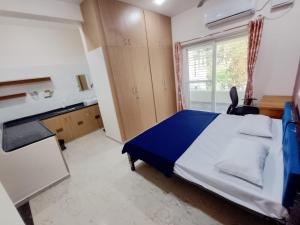 a bedroom with a bed and a desk and a window at RV Comforts in Perambalūr