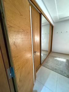 an empty room with a wooden door and a hallway at Pearl Beach Apartment in Monastir