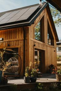 a wooden shed with a fan and potted plants at Gardiasówka na Roztoczu in Chlewiska