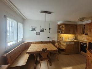 a kitchen with a wooden table in the middle of it at Wohnung in Andermatt in Andermatt