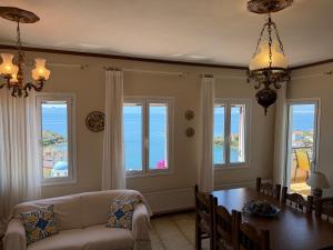 a living room with a table and chairs and windows at Blue Horizon Balcony in Volos +23 photos