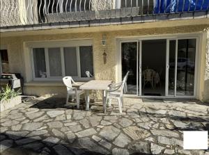 a patio with a table and chairs on a stone patio at Logis PONIENTE in Arles-sur-Tech