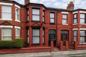 a red brick house with a gate in front of it at Rockland Retreat - Near Crosby Beach & Liverpool in Waterloo