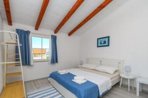 a bedroom with a bed and a ladder and a window at Apartments Sime in Lopar