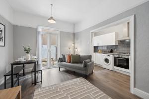 a living room with a couch a table and a kitchen at Rockland Retreat - Near Crosby Beach & Liverpool in Waterloo