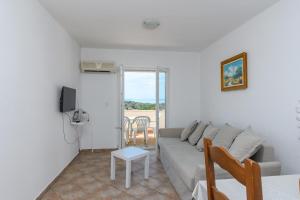 a living room with a couch and a table at Apartments Sime in Lopar