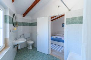 a bathroom with a sink and a toilet and a bed at Apartments Sime in Lopar +73 photos