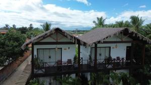 a house with a thatched roof and a balcony at Pousada Angelim in Santo Amaro