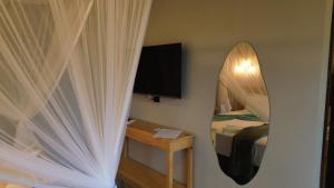 a room with a mirror and a bed with a bed sqor at Pousada Angelim in Santo Amaro