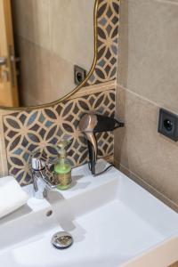 a bathroom sink with a blow dryer and a mirror at Riad Villa Alain in Nouaceur