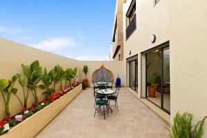 a patio with a table and chairs on a building at Riad Villa Alain in Nouaceur