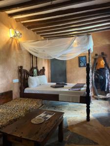 a bedroom with a bed and a wooden table at Sazani Beach Lodge and Tidal Lounge in Nungwi