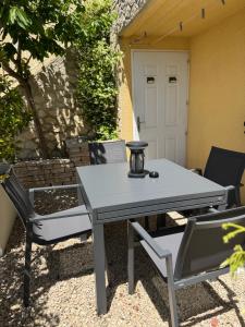 a picnic table and two chairs on a patio at bas de Villa "Le Tiste" in Valensole +5 photos