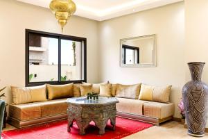 a living room with a couch and a table at Riad Villa Alain in Nouaceur