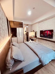 a bedroom with a large bed with a flat screen tv at P4 Type Studio Apt Swimming Pool View Batam Centre in Batam Center