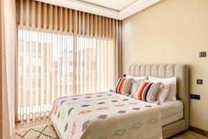 a bedroom with a bed and a large window at Riad Villa Alain in Nouaceur +49 photos