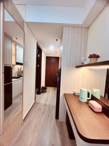 a room with a wooden table and a kitchen at P4 Type Studio Apt Swimming Pool View Batam Centre in Batam Center