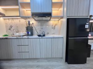 a kitchen with a black refrigerator and a sink at P4 Type Studio Apt Swimming Pool View Batam Centre in Batam Center +10 photos