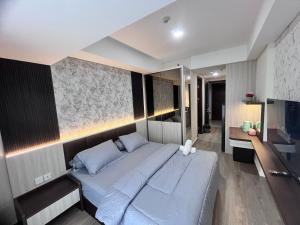 a bedroom with a large bed and a television at P4 Type Studio Apt Swimming Pool View Batam Centre in Batam Center