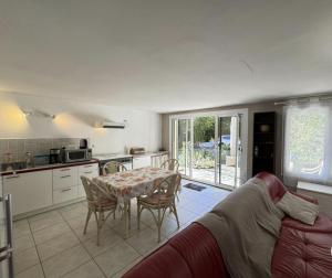 a living room with a couch and a table and a kitchen at Logis PONIENTE in Arles-sur-Tech