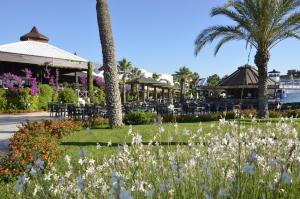 a garden with flowers in front of a restaurant at Emelda Sun Club in Kemer