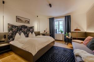 a bedroom with a large bed and a couch at Hotel Gasthof Prunner in Gmünd in Kärnten