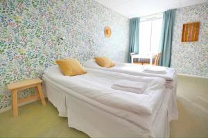 Zwei Betten in einem Zimmer mit Blumentapete in der Unterkunft Vita huset at Stora Le in Ed