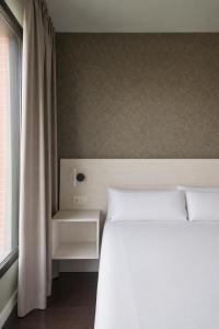a bedroom with a white bed and a window at RICE Bulevar in Burgos