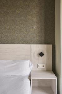 a bedroom with a white bed and a wooden headboard at RICE Bulevar in Burgos