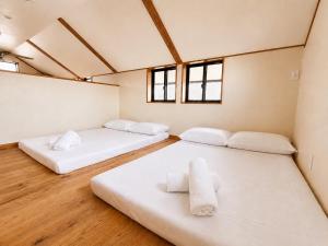 two beds in a room with two windows at Hamabun テラスでBBQ 湖まで徒歩5分 無料駐車場3台 in Takashima