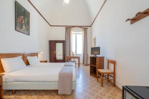 a hotel room with a bed and a television at Pensione Di Lustro in Forio d'Ischia
