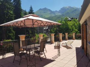 a table and chairs under an umbrella on a patio at Villa Teresa in Limone Piemonte