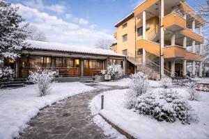a house in the snow with a pathway in front at Вила Стряма in Hisarya
