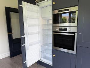 a kitchen with an open refrigerator and an open door at Number 6 Westpark Spanish Point in Spanish Point