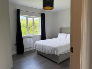 a bedroom with a bed and a window at Number 6 Westpark Spanish Point in Spanish Point