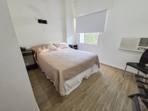 a bedroom with a bed and a window and a chair at Hotel Milton in La Paz