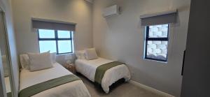 a bedroom with two beds and a window at Sage & Salt in St. Helena Bay