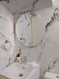 a white bathroom with a sink and a mirror at HcHOME in Algeciras